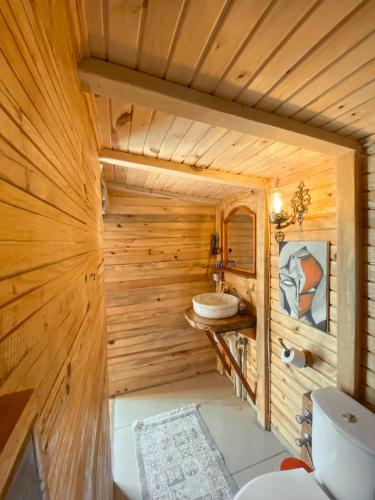 a wooden bathroom with a toilet and a sink at 11-11Shambala in Fethiye