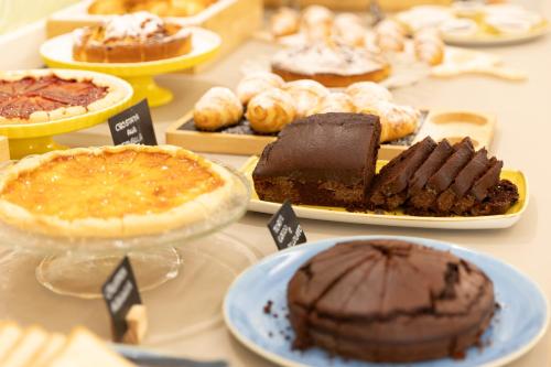 a table topped with different types of cakes and pies at Hotel La Nidiola in Riccione
