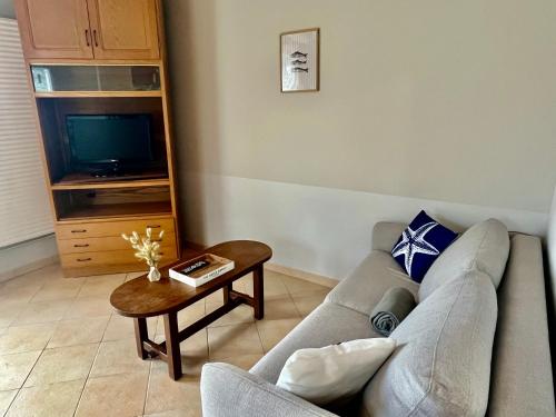a living room with a couch and a coffee table at Gîtes de la Mouette La Moussette 5-6 personnes in Ravenoville