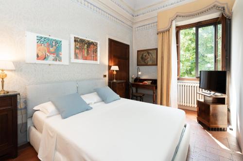 a bedroom with a large white bed and a window at VillAmorosa in Calci