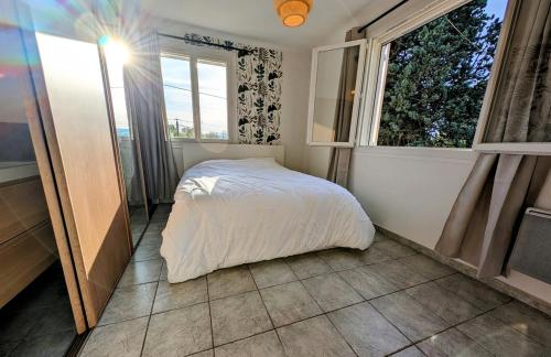 ein Schlafzimmer mit einem weißen Bett und einem Fenster in der Unterkunft Villa 7 chambres, piscine et jardins privés, pas de voisins in Le Thor