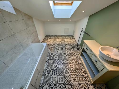 ein Badezimmer mit Waschbecken und Badewanne in der Unterkunft Villa 7 chambres, piscine et jardins privés, pas de voisins in Le Thor