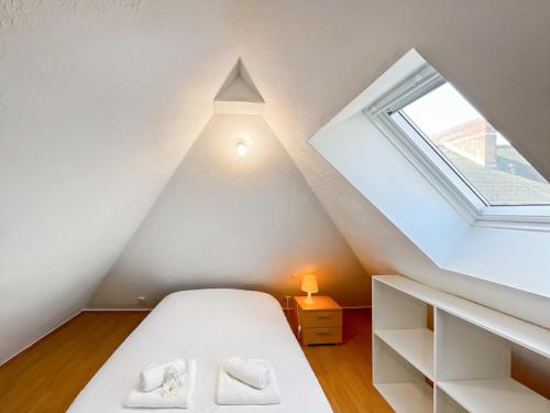 une chambre mansardée avec un lit et une fenêtre dans l'établissement Adamite - Centre Historique - Proche gare - Calme, à Rennes