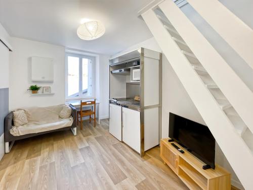 - un salon avec une télévision et un escalier dans l'établissement Adamite - Centre Historique - Proche gare - Calme, à Rennes
