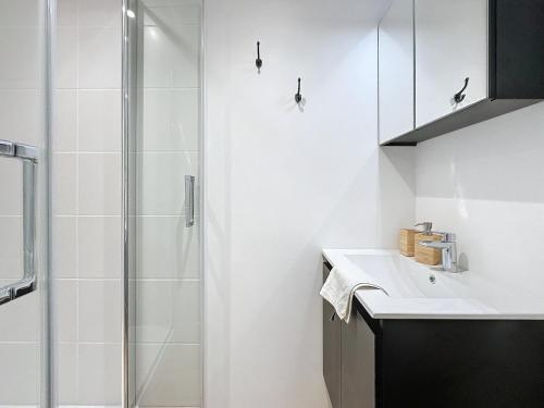 une salle de bain blanche avec une douche et un lavabo dans l'établissement Adamite - Centre Historique - Proche gare - Calme, à Rennes