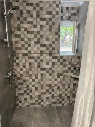 a bathroom with a tiled shower with a shower curtain at Nefeli's Hut in Mytilene