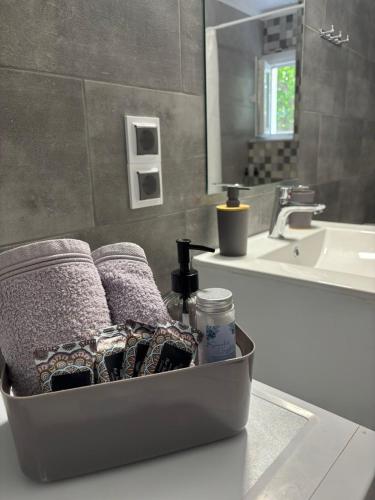 a bathroom with a container of towels and a sink at Nefeli's Hut in Mytilene