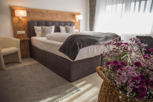a bedroom with a bed and flowers in a basket at Familienhotel Friedrichshof in Obertrubach