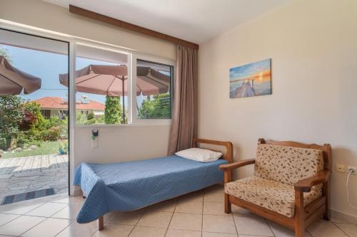 a bedroom with a bed and a chair and a window at Christianna studios in Nikiana