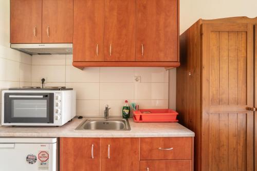 a kitchen with a sink and a microwave at Christianna studios in Nikiana
