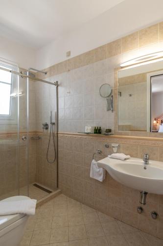 a bathroom with a shower and a sink and a mirror at Ostria Hotel  in Adamas