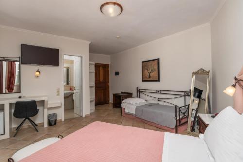 a bedroom with a bed and a desk and a bed at Ostria Hotel  in Adamas
