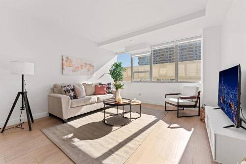 a living room with a couch and a tv at Modern Retreat in Koreatown - Perfect for Your LA Stay! in Los Angeles