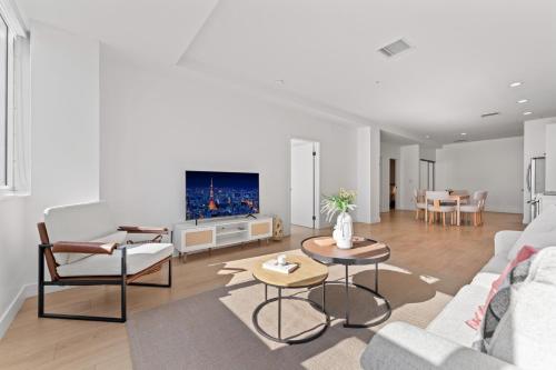 Una sala de estar con un sofá y un televisor. en Modern Retreat in Koreatown - Perfect for Your LA Stay!, en Los Ángeles