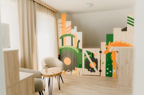 a living room with a painting of a tractor on the wall at Familienhotel Friedrichshof in Obertrubach