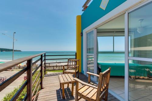 a balcony with chairs and a view of the ocean at Residencial Vila do Sol, Apartamentos com pé na areia in Bombinhas