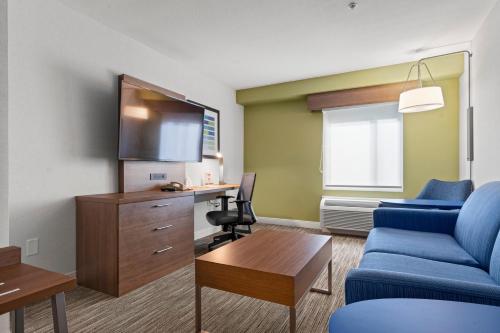 a living room with a blue couch and a desk at Holiday Inn Express and Suites Surrey by IHG in Surrey