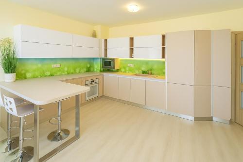 eine Küche mit weißen Schränken und grünen Wänden in der Unterkunft La Mer Sea View & Beachfront Apartment in Warna