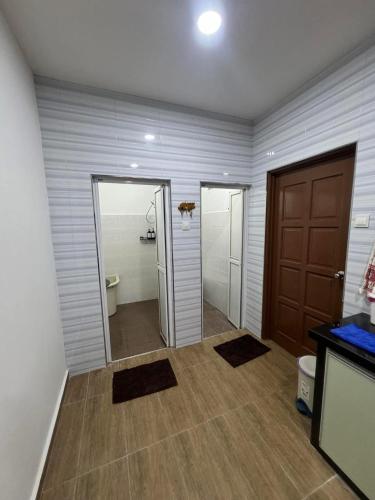 a hallway with a bathroom with a toilet and a door at Best Day Homestay ! in Kangar