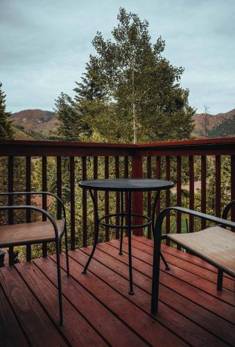 a table and two chairs on a wooden deck at Cobalt Peak - Pet-Friendly Sauna Panoramic Views in Cascade-Chipita Park