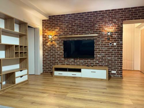 a living room with a brick wall and a flat screen tv at Aparthotel Praha in Prague