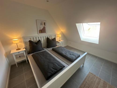 ein Schlafzimmer mit einem Bett mit zwei Kissen und einem Fenster in der Unterkunft Ferienwohnung Seescheune 150m vom Ufer entfernt in Bodman-Ludwigshafen