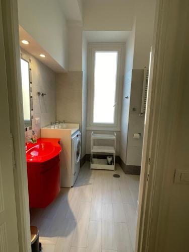 a bathroom with a red sink and a washing machine at Docking House in Lido di Ostia