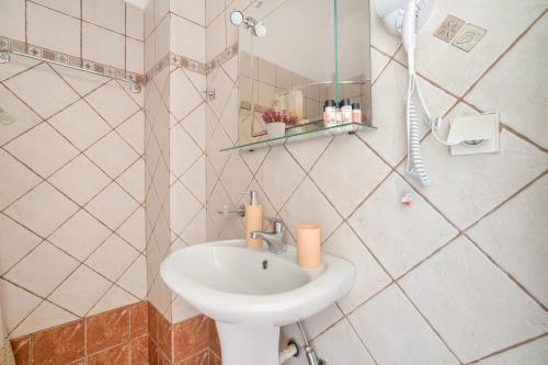 a bathroom with a sink and a mirror at Christianna studios in Nikiana