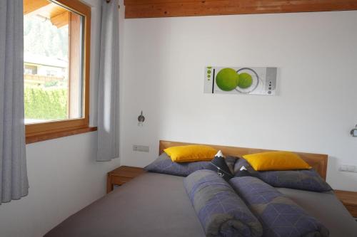 a bedroom with a bed with blue pillows and a window at Appartement Carola in Sankt Gallenkirch