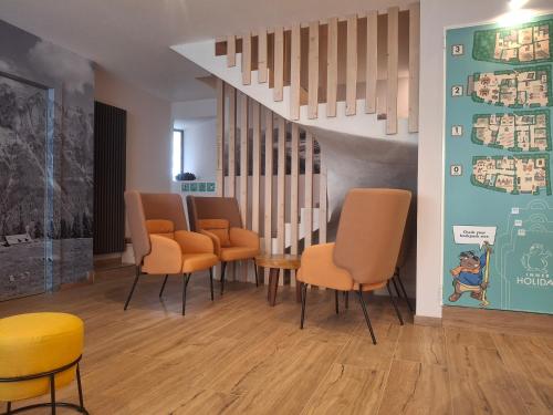 a waiting room with orange chairs and a staircase at Inner Holiday Dolomites 5 in Dimaro