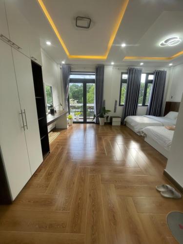a bedroom with a bed and a wooden floor at Trần Lê Hostel in Da Lat