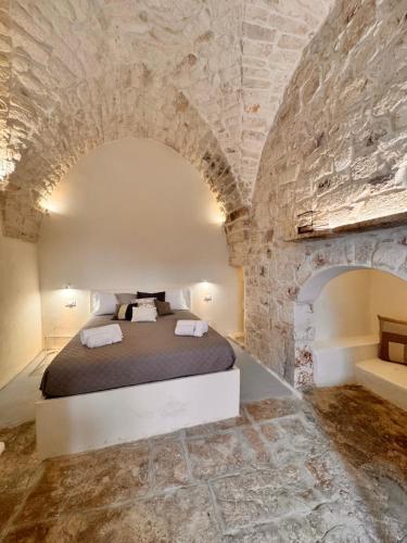 a bedroom with a bed in a stone wall at Bianca Ostuni in Ostuni