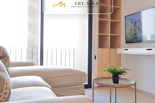 a living room with white furniture and a tv at Soho Morelos in Guadalajara