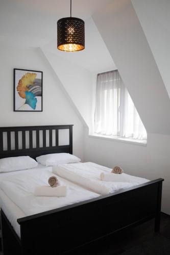 a bedroom with a bed with white sheets and a window at Villa Sole Apartman Balatonboglár in Balatonboglár