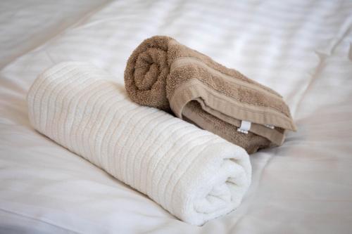 a rolled up towel on a bed at Villa Sole Apartman Balatonboglár in Balatonboglár