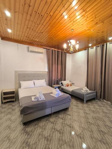 a bedroom with two beds and a chandelier at VILLA PORTIANOU in Pedhinón