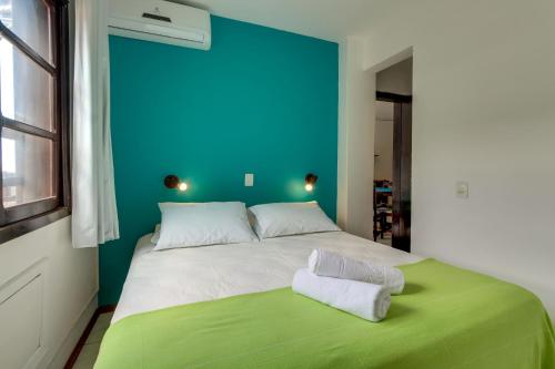 a bedroom with a large bed with a blue wall at Residencial Vila do Sol, Apartamentos com pé na areia in Bombinhas