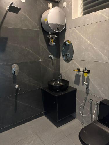 a bathroom with a sink and a mirror on the wall at Kalarava private rooms in Chikmagalūr