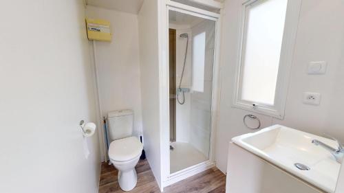 une salle de bain blanche avec des toilettes et un lavabo dans l'établissement Cabane des Dunes, à Saint-Jean-de-Monts