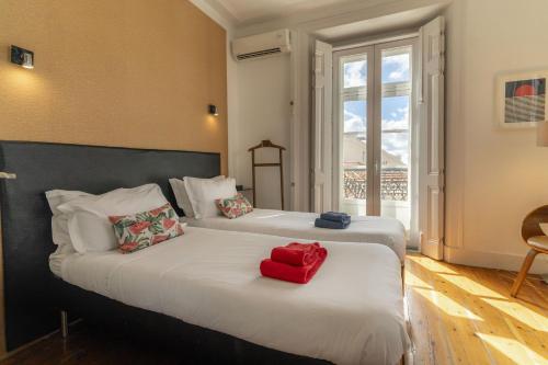 two beds in a hotel room with a red box on them at LV Premier Apartments Baixa- CN in Lisbon