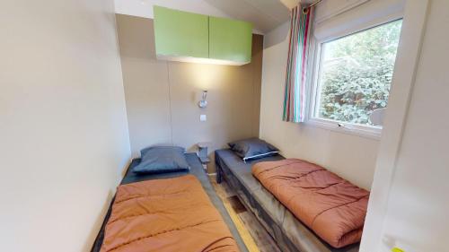 deux lits dans une petite pièce avec une fenêtre dans l'établissement Azur Ocean avec terrasse, à Saint-Jean-de-Monts