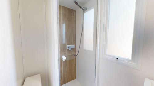 La salle de bains est pourvue d'une douche et d'une fenêtre. dans l'établissement Azur Ocean avec terrasse, à Saint-Jean-de-Monts