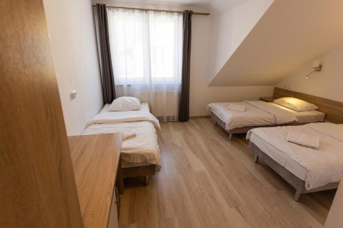 a room with three beds and a window at Kresovia in Giby
