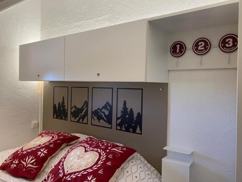 a bedroom with a bed with a red comforter at Studio pieds des pistes - Cosy & Confort in Ustou