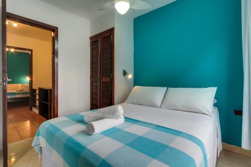 a bedroom with a bed with a blue wall at Residencial Vila do Sol, Apartamentos com pé na areia in Bombinhas