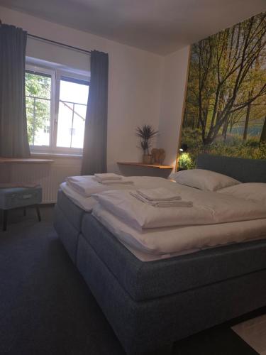 a large bed in a bedroom with a window at Gasthof zum Schiffmeister in Wesenufer