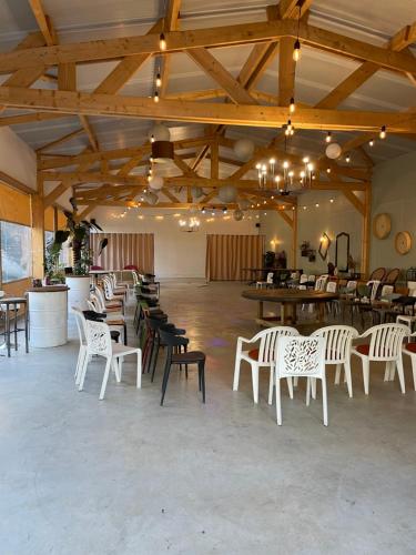 a large room with white chairs and tables in it at Maison du WHITE ROCK in Saint-Jouan-des-Guérets