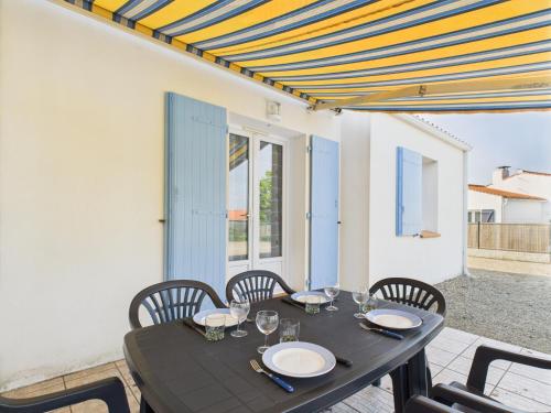 - une table à manger avec des chaises, une table, une table et des chaises dans l'établissement Maison de vacances pour 4, St-Hilaire-de-Riez, à Saint-Hilaire-de-Riez