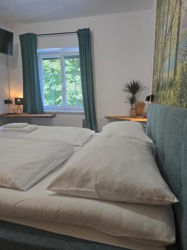 a large white bed with pillows and a window at Gasthof zum Schiffmeister in Wesenufer