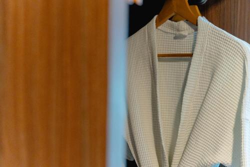 a group of white shirts are hanging on a closet at Happy Hotel Aonang Krabi in Ao Nang Beach